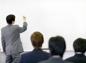 Businessman Writing on Whiteboard --- Image by © Royalty-Free/Corbis